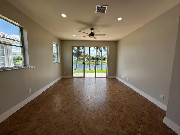 an empty room with windows and ceiling fan