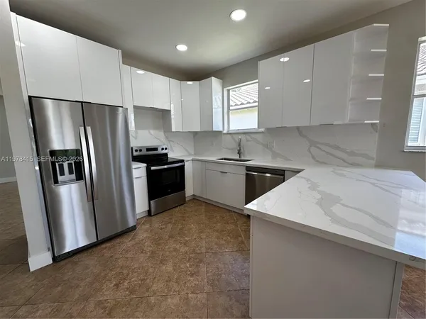 a kitchen with stainless steel appliances a refrigerator sink and microwave