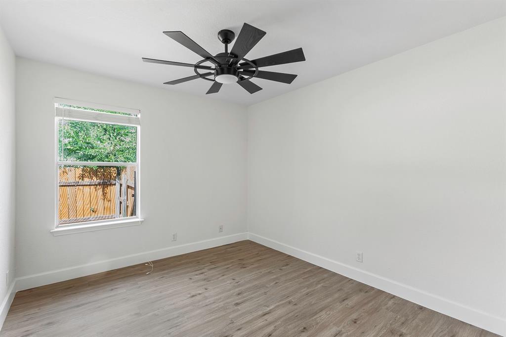 617 Barbara Way Bastrop, TX 78602 - Photo 12 of 20 Bright and airy, this room features plank flooring and a modern ceiling fan, offering a tranquil retreat.