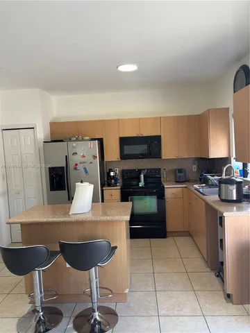 a kitchen with stainless steel appliances kitchen island granite countertop a sink and a stove