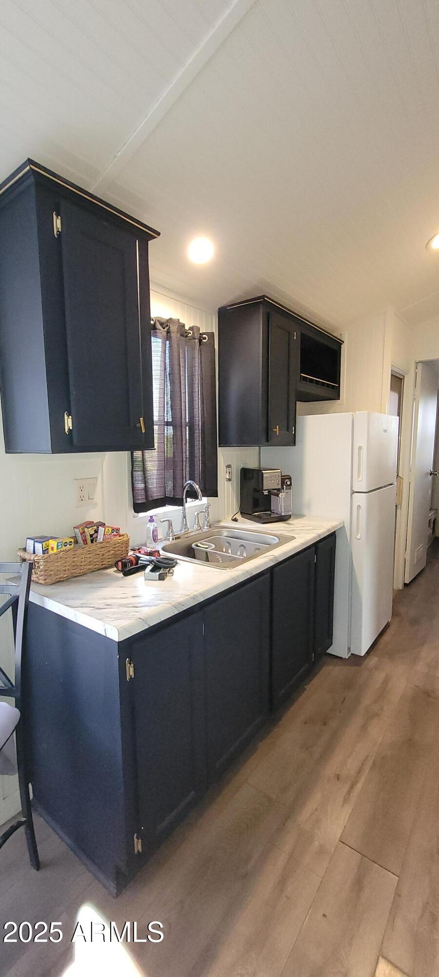 22219 West Blue Sky Drive, Unit CASITA Wittmann, AZ 85361 - Photo 2 of 15 a kitchen with a sink and a refrigerator