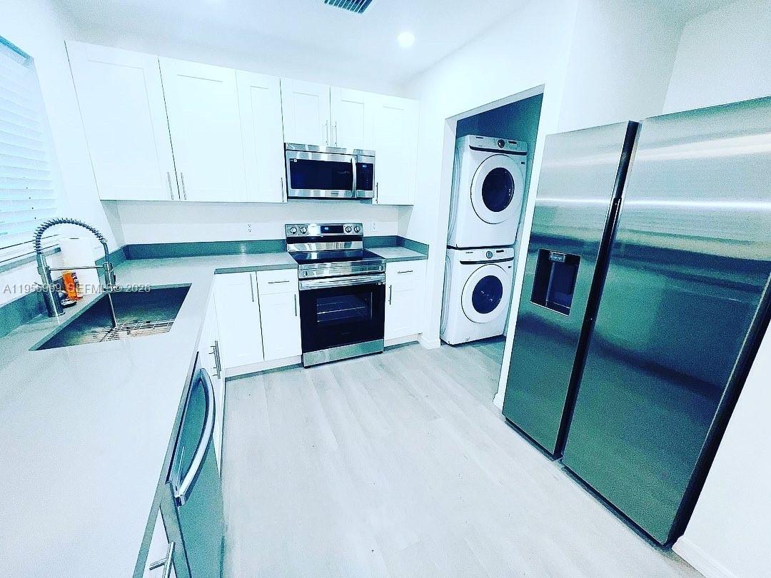 7128 Southwest 22nd Street, Unit 7128 Miami, FL 33155 - Photo 2 of 19 a kitchen with stainless steel appliances granite countertop a stove a sink and a microwave