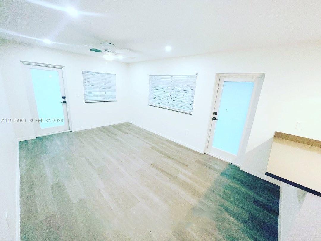 7128 Southwest 22nd Street, Unit 7128 Miami, FL 33155 - Photo 5 of 19 an empty room with wooden floor and windows
