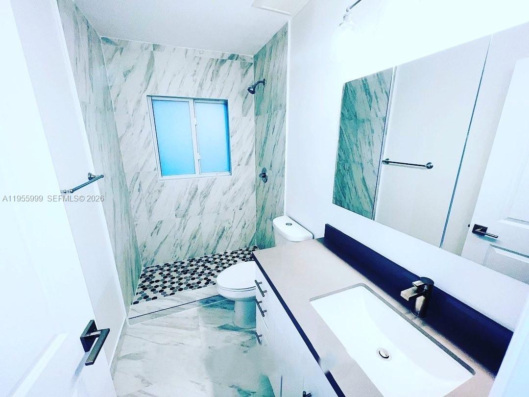 7128 Southwest 22nd Street, Unit 7128 Miami, FL 33155 - Photo 6 of 19 a bathroom with a sink a toilet and shower