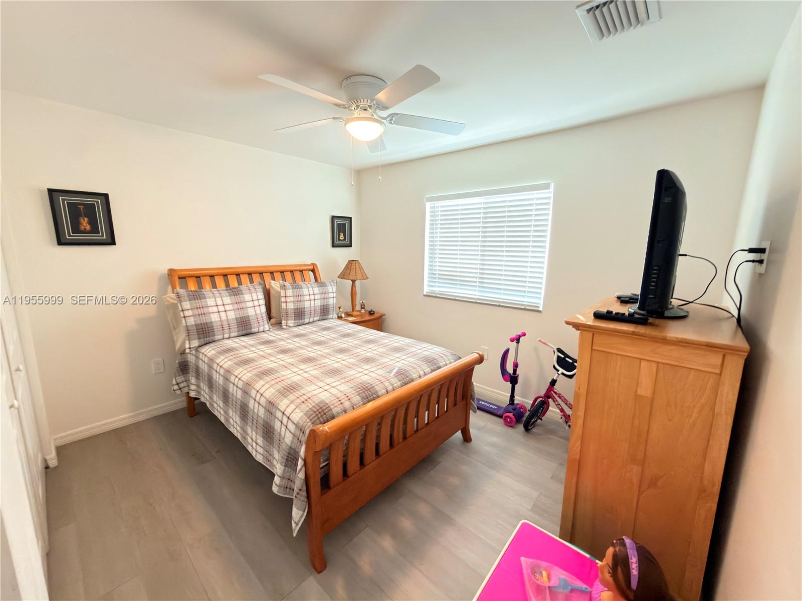 7128 Southwest 22nd Street, Unit 7128 Miami, FL 33155 - Photo 9 of 19 a bedroom with a bed and a flat screen tv