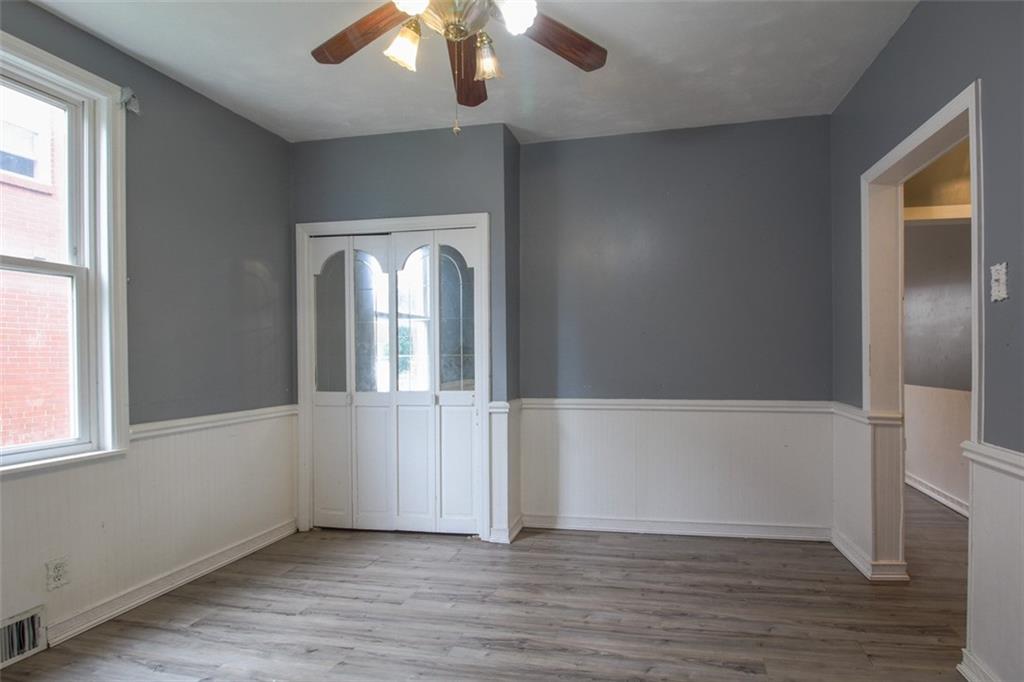 202 Jane Street McKees Rocks, PA 15136 - Photo 14 of 44 an empty room with wooden floor fan and windows