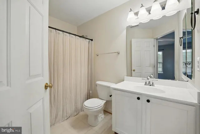 a bathroom with a sink vanity mirror and toilet