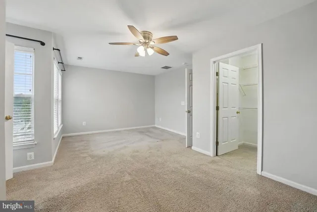 an empty room with closet and fan