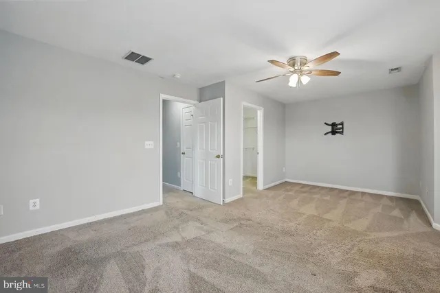 a view of empty room with a ceiling fan and window
