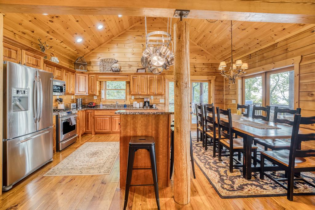 1447 Grandeur Drive Blue Ridge, GA 30513 - Photo 12 of 60 a kitchen with stainless steel appliances kitchen island granite countertop a refrigerator a stove and a dining table with wooden floors