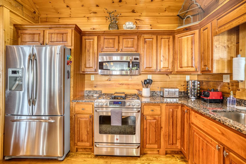 1447 Grandeur Drive Blue Ridge, GA 30513 - Photo 14 of 60 a kitchen with stainless steel appliances granite countertop a refrigerator a stove and a sink