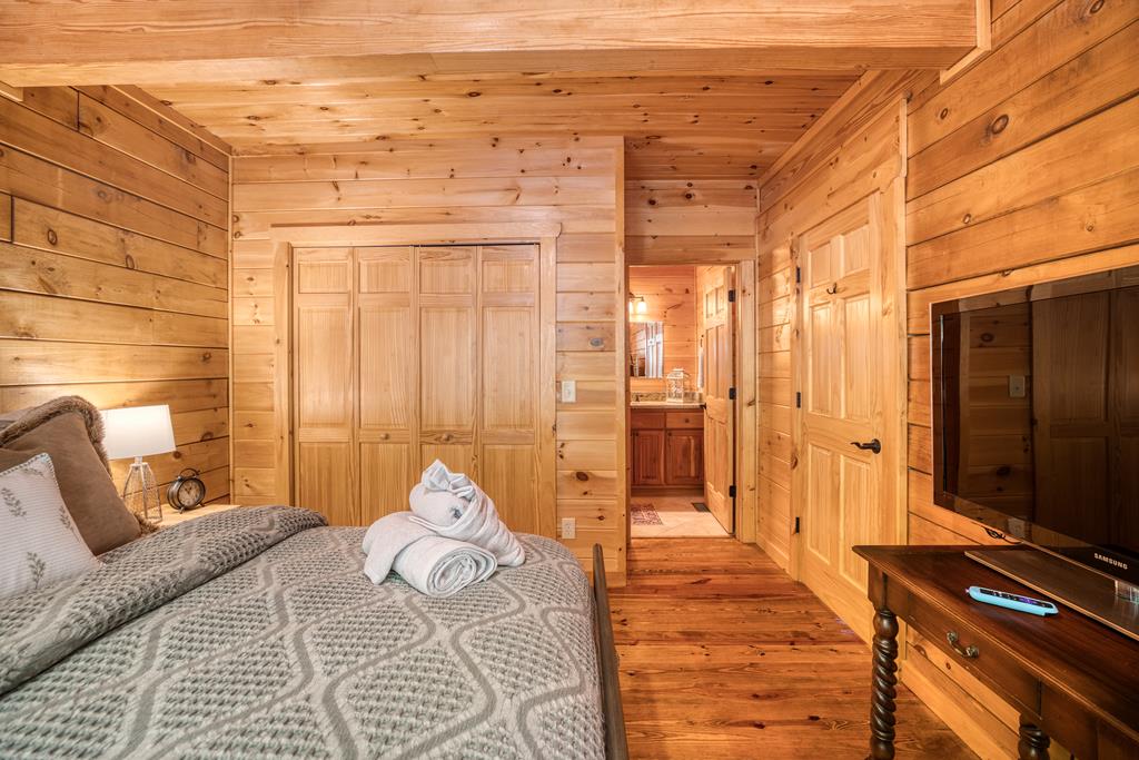 1447 Grandeur Drive Blue Ridge, GA 30513 - Photo 28 of 60 a bedroom with a bed and a flat screen tv