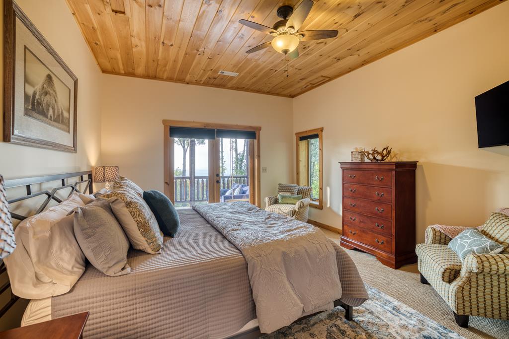 1447 Grandeur Drive Blue Ridge, GA 30513 - Photo 40 of 60 a bedroom with a bed and a chandelier