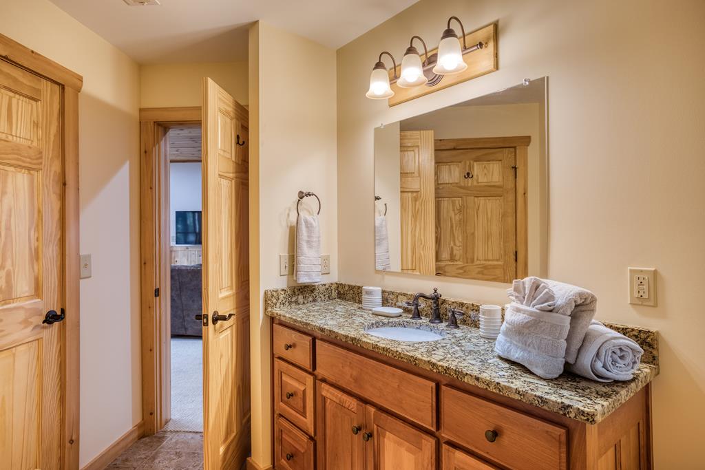 1447 Grandeur Drive Blue Ridge, GA 30513 - Photo 49 of 60 a bathroom with sinks granite countertop tub and a mirror