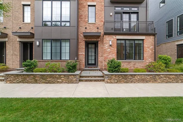 front view of a brick house with a yard