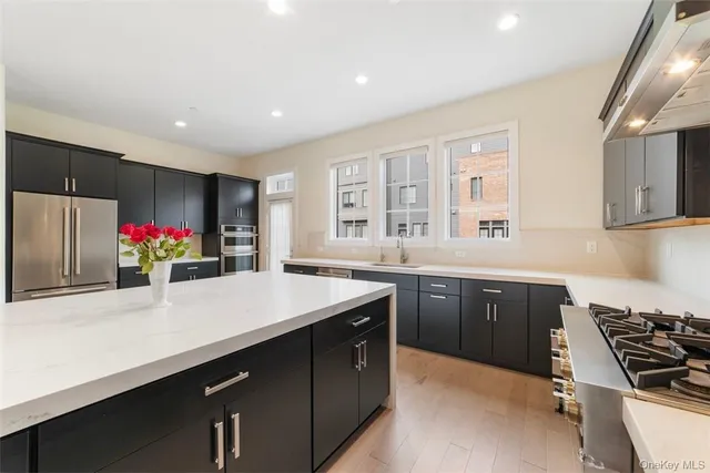 a kitchen with stainless steel appliances granite countertop a sink and stove top oven