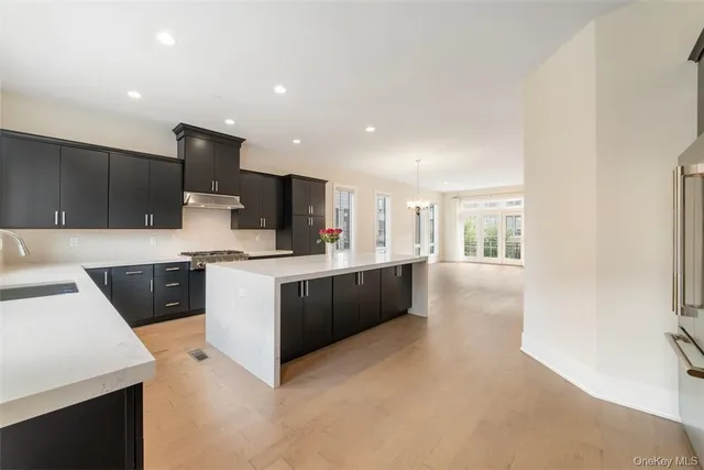 a large kitchen with stainless steel appliances kitchen island granite countertop a large counter top and a stove top oven