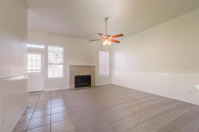 an empty room with windows and fireplace