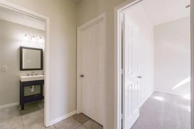 a view of a hallway and a bathroom with a sink