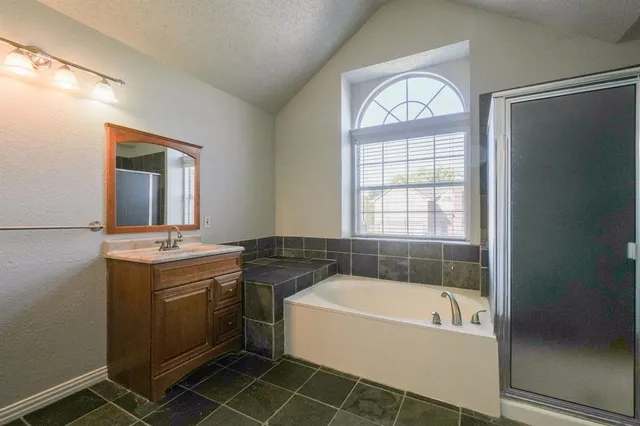 a bathroom with a tub sink and mirror