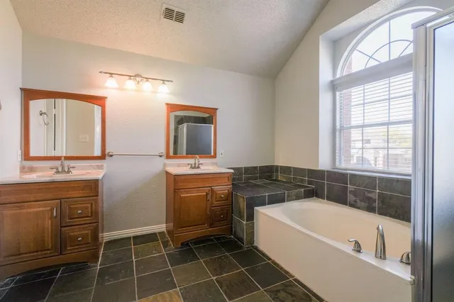 a bathroom with a tub sink and mirror