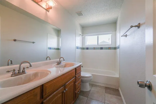 a bathroom with a sink toilet double vanity and tub