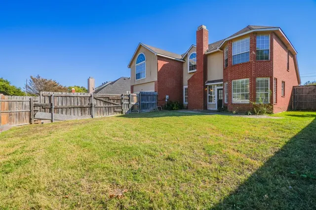 a view of a house with a yard and a tree