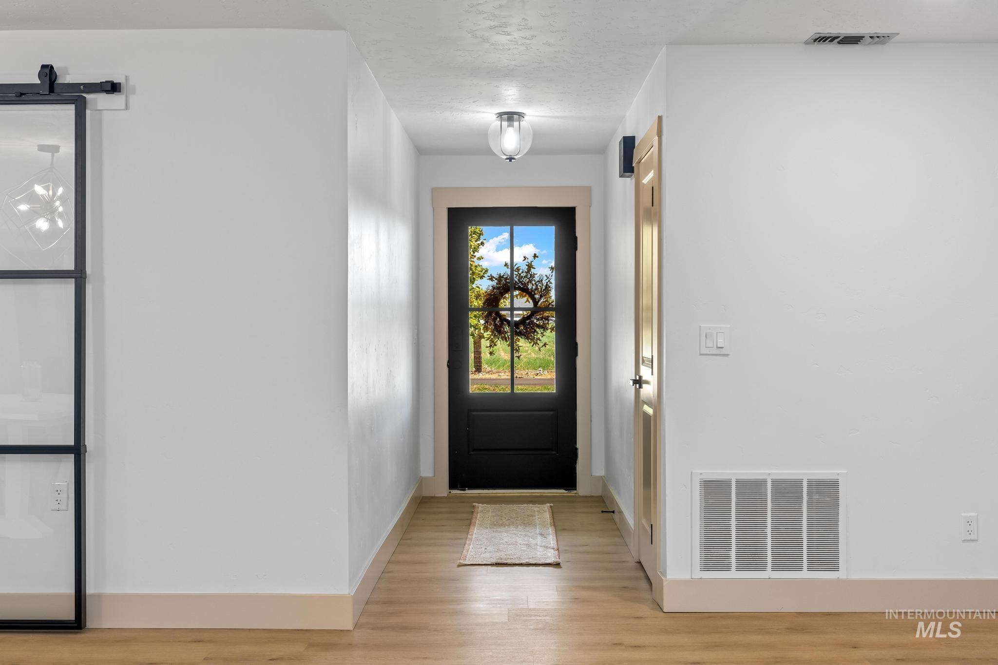 8500 Washoe Road Payette, ID 83661 - Photo 13 of 50 Foyer entrance with light wood-type flooring and a barn door