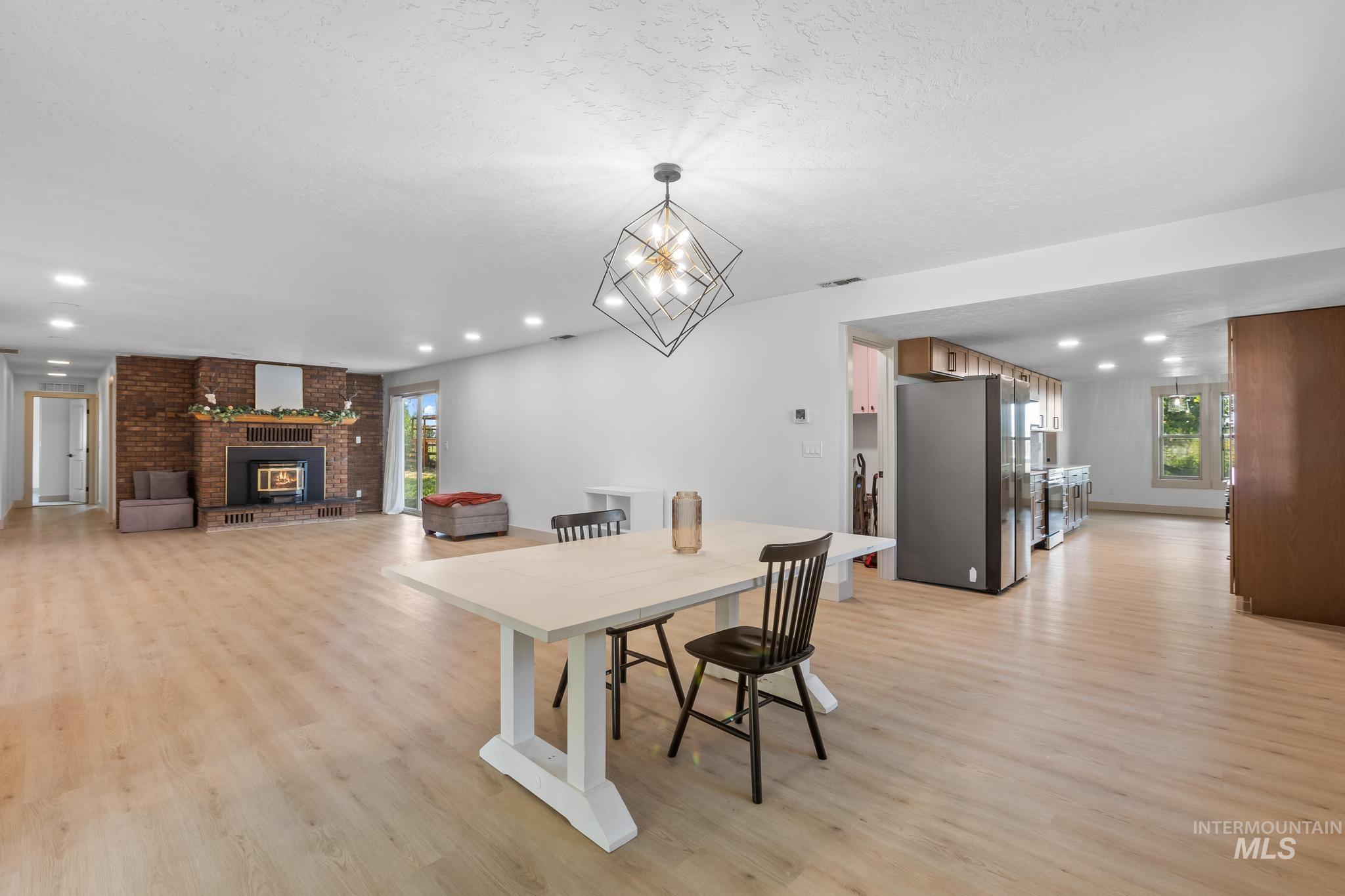8500 Washoe Road Payette, ID 83661 - Photo 19 of 50 Dining area featuring light wood-type flooring, a fireplace, recessed lighting, and a textured ceiling