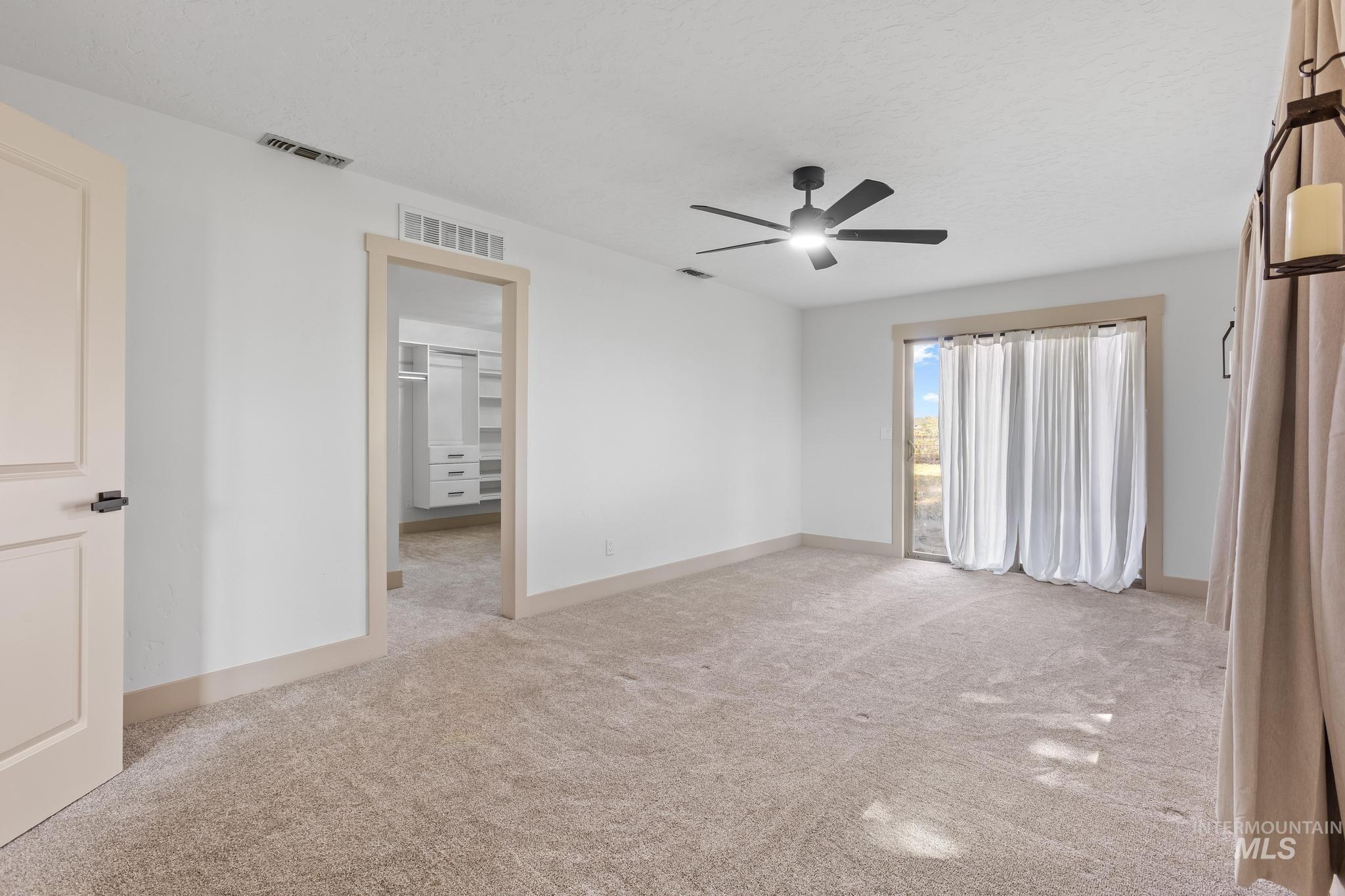 8500 Washoe Road Payette, ID 83661 - Photo 28 of 50 Unfurnished bedroom featuring light carpet, ceiling fan, and a walk in closet