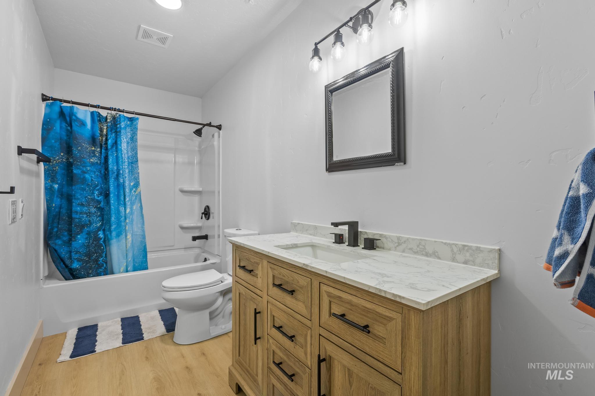 8500 Washoe Road Payette, ID 83661 - Photo 41 of 50 Bathroom with vanity, shower / tub combo with curtain, and wood finished floors