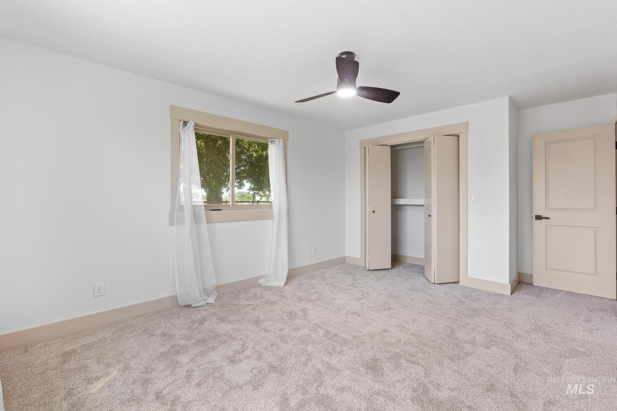 8500 Washoe Road Payette, ID 83661 - Photo 42 of 50 Unfurnished bedroom with light carpet, a ceiling fan, and a closet