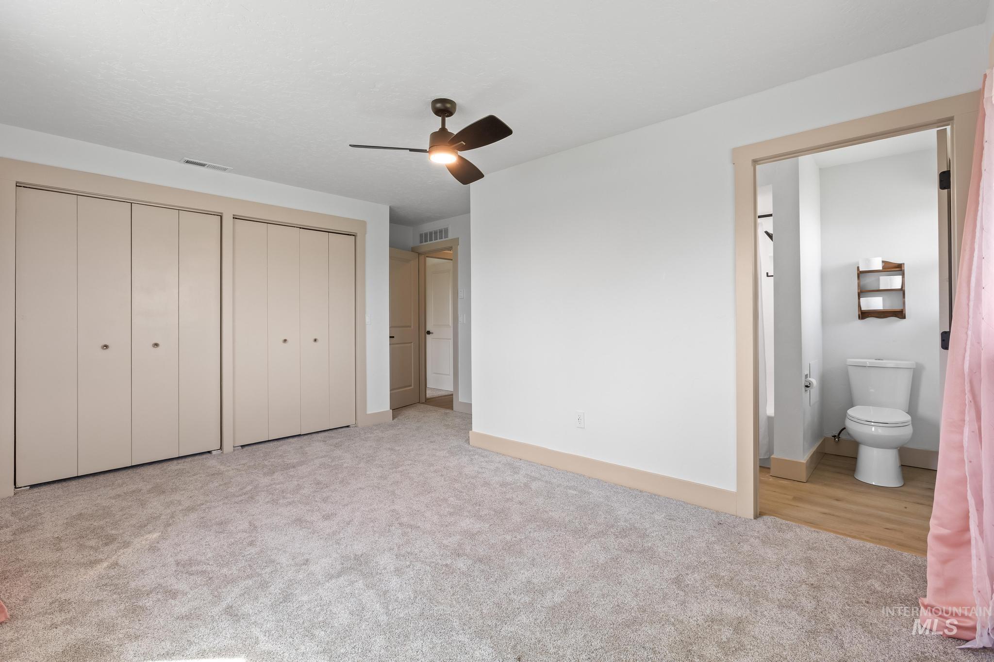 8500 Washoe Road Payette, ID 83661 - Photo 45 of 50 Unfurnished bedroom with multiple closets, carpet floors, connected bathroom, and ceiling fan
