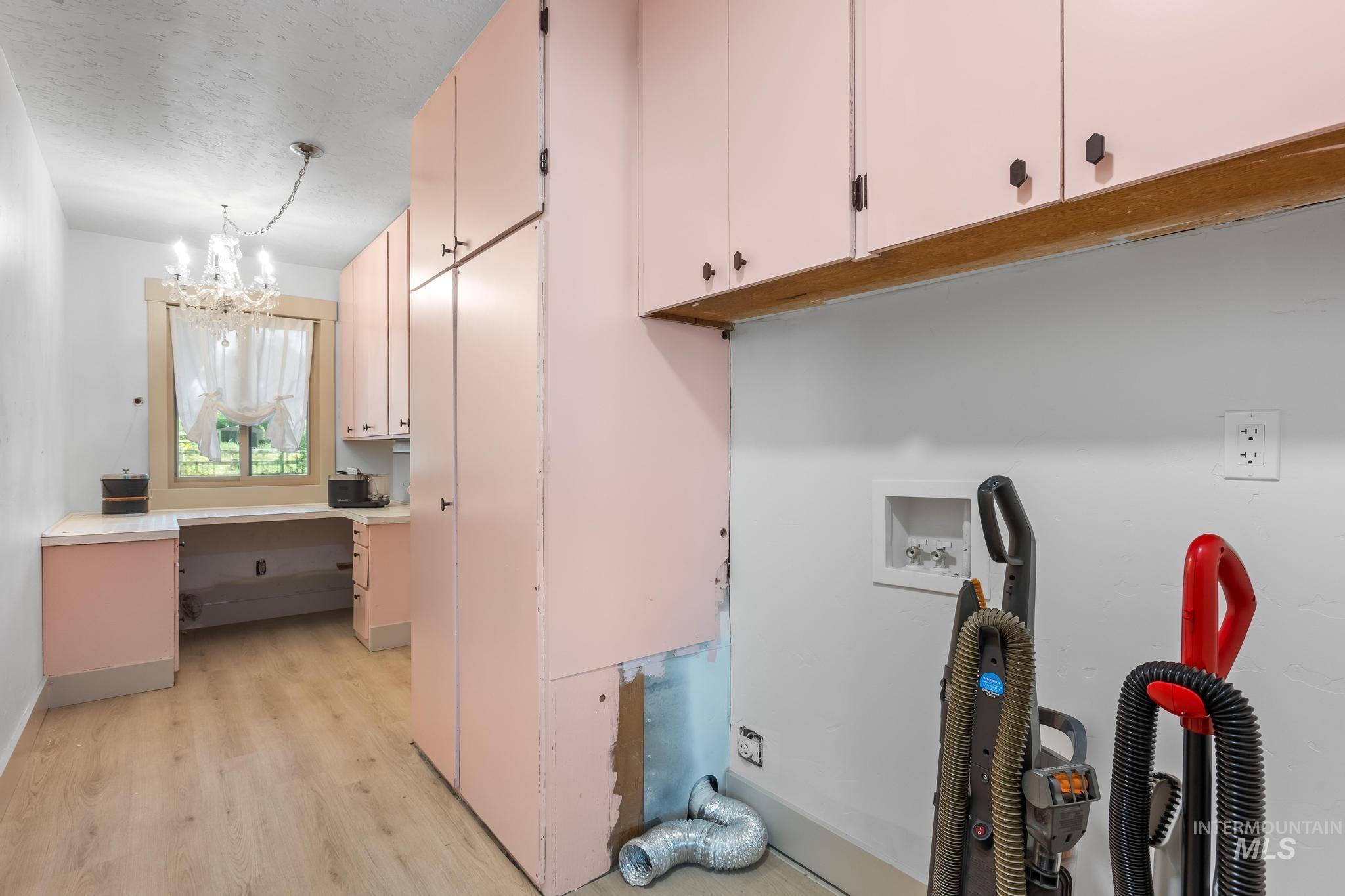 8500 Washoe Road Payette, ID 83661 - Photo 47 of 50 Laundry area with cabinet space, washer hookup, a chandelier, a textured ceiling, and light wood-style floors