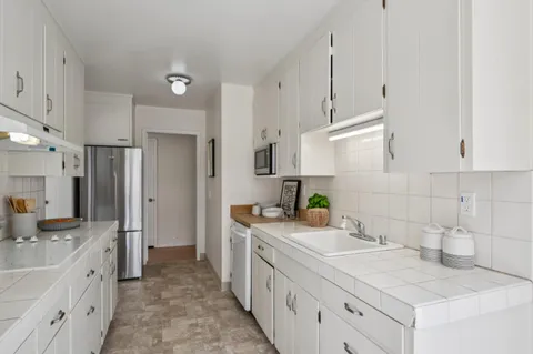 a kitchen with stainless steel appliances a sink stove refrigerator and cabinets