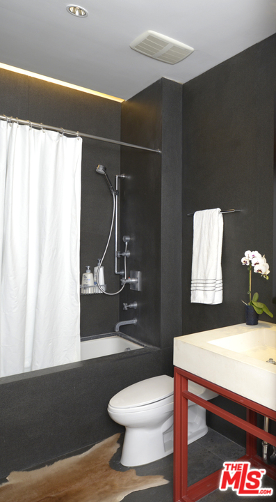 257 South Spring Street, Unit PHMN Los Angeles, CA 90012 - Photo 13 of 17 a bathroom with a sink a toilet and shower