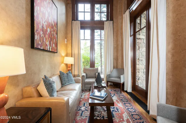 a living room with furniture and floor to ceiling windows