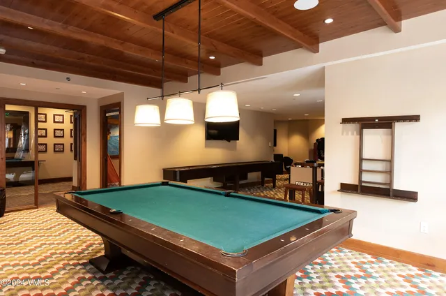 a room with pool table and a rug