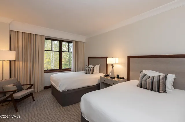 a bedroom with two beds and large window