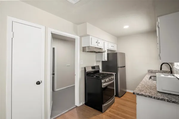 a kitchen with granite countertop a stove and a sink