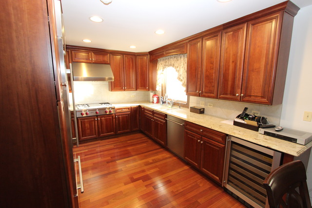 11 Deepwood Road Barrington, IL 60010 - Photo 16 of 25 a kitchen with stainless steel appliances granite countertop wooden cabinets a sink and a stove