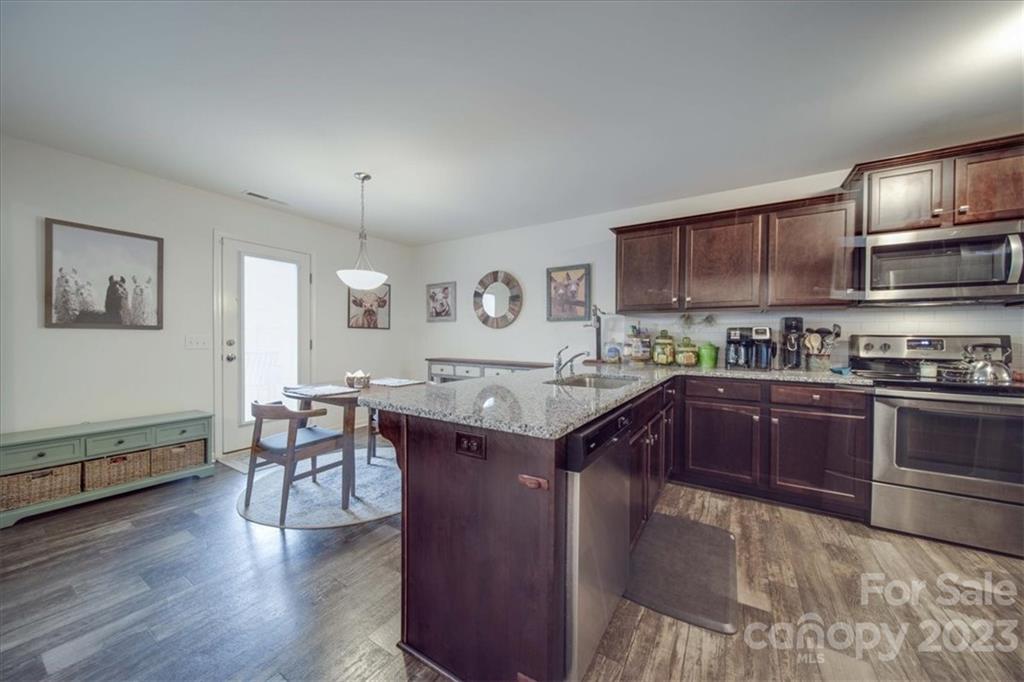 12542 Garron Road Midland, NC 28107 - Photo 23 of 38 a kitchen with stainless steel appliances granite countertop a stove a sink dishwasher and cabinets with wooden floor
