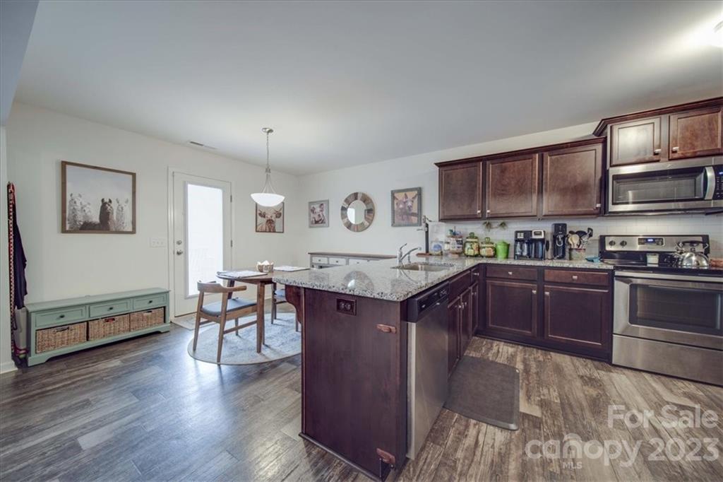 12542 Garron Road Midland, NC 28107 - Photo 24 of 38 a kitchen with stainless steel appliances granite countertop a stove a sink dishwasher and a refrigerator with wooden floor