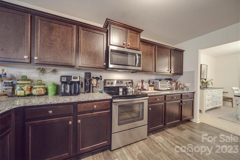 12542 Garron Road Midland, NC 28107 - Photo 26 of 38 a kitchen with stainless steel appliances granite countertop wooden cabinets a stove a sink and dishwasher