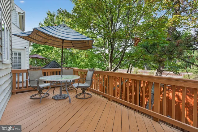 a balcony with wooden floor table and chairs