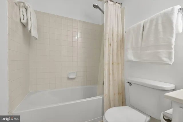 a white toilet sitting next to a bath tub