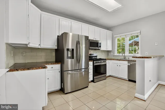 a kitchen with a table chairs refrigerator and cabinets