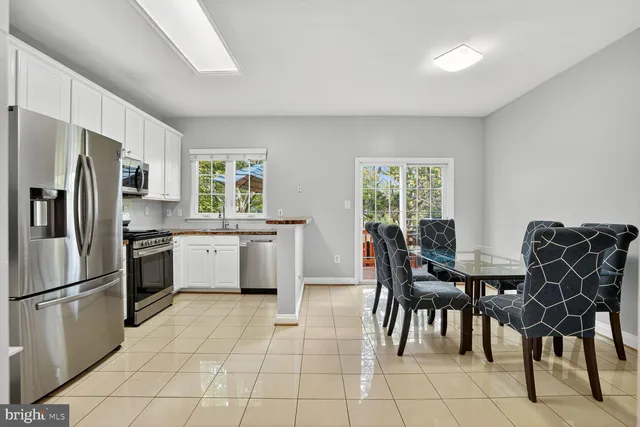 a kitchen that has a lot of cabinets a sink and appliances