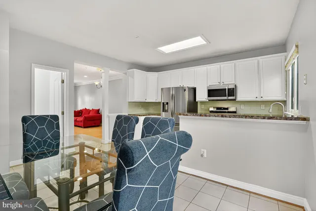 a kitchen with stainless steel appliances kitchen island granite countertop a refrigerator and microwave