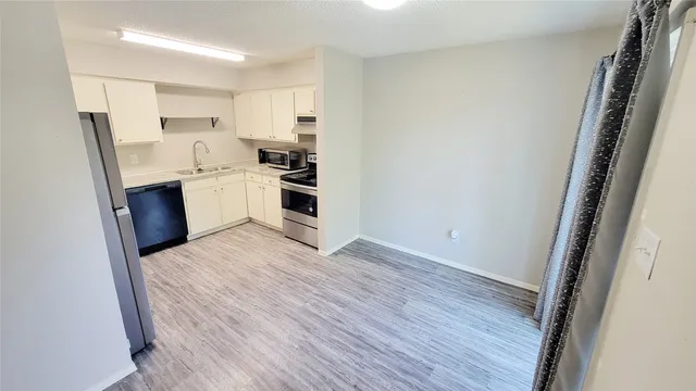 a kitchen with wooden floors and white appliances